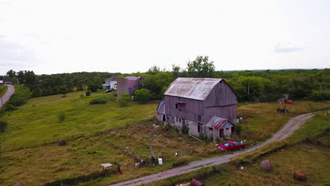 Aerial-flying-around-a-weathered,-old-barn-in-the-countryside