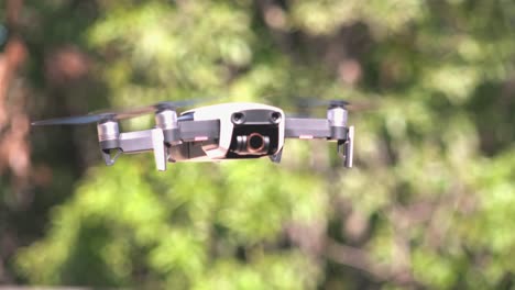 Close-Shot-of-a-Drone-Flying-with-Trees-in-the-Background
