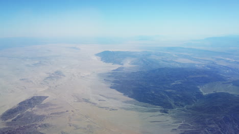 High-altitude-aerial-flying-over-the-desert-on-a-bright-sunny-day