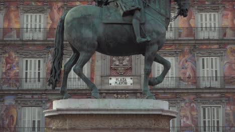 Ampliar-Para-Firmar-En-La-Plaza-Mayor-De-Madrid-España-Entre-Las-Piernas-De-La-Estatua-Del-Rey-Felipe-Iii