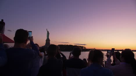 Touristen-Fotografieren-Die-Freiheitsstatue-In-Der-Abenddämmerung-Von-Einem-Boot-Aus