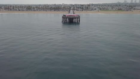 Calm-Seas-Tilt-Up-Reveal-Pier-End-and-West-Coast-Beach-Title-Shot