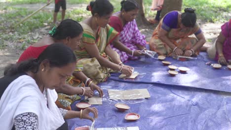 Asian-rural-tribal-women-sitting-and-working-together-at-non-profit-organisation,-handcraft-items,-feminism,-outdoor-shot