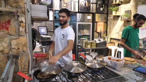 Man-flip-malawach,-small-street-food-takeout-counter,-Jerusalem-Mahane-Yehuda