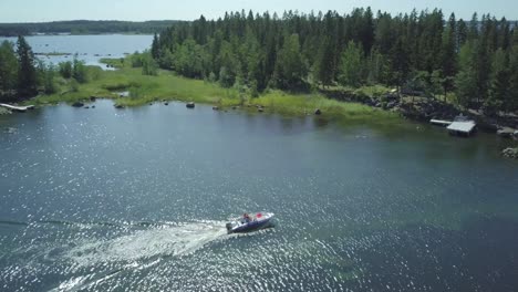 Antena-De-Barco-Navegando-A-Través-De-Un-Lago-De-Aguas-Poco-Profundas-En-Un-Archipiélago-Rocoso