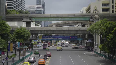 Bts-Skytrain-Moviéndose-Sobre-Una-Carretera-Muy-Transitada-En-El-Centro-De-La-Ciudad-De-Bangkok,-Movimiento-Rápido