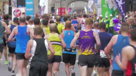 Mid-shot-of-group-of-London-Marathon-runners-crossing-London-Bridge
