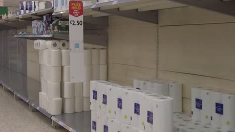 Slow-motion-interior-empty-shelf-UK-supermarket-panic-buying-toilet-rolls-corona-virus