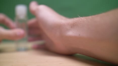 Equate-hand-sanitizer-bottle-spun-by-hands-into-focus,-closeup