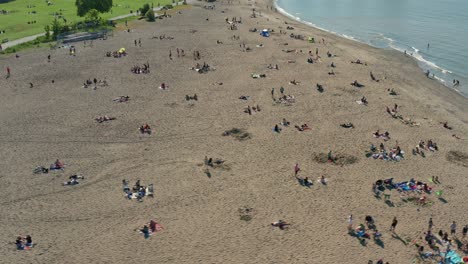 Vista-Aérea-De-Personas-Que-Se-Relajan-En-Una-Playa-Siguiendo-Las-Reglas-De-Distanciamiento-Social-Después-De-Que-Las-Restricciones-De-La-Ciudad-Disminuyen-De-La-Pandemia-De-Covid-19