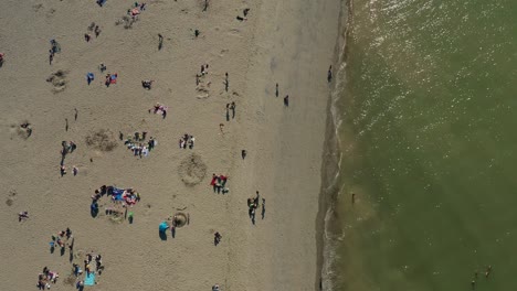 Von-Oben-Nach-Unten-Luftaufnahme-Von-Familien,-Die-Sich-An-Einem-Strand-Versammeln,-Nachdem-Die-Beschränkungen-In-Der-Stadt-Aufgrund-Der-Covid-19-Pandemie-Gelockert-Wurden