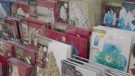 Elegantes-Diseños-De-Tarjetas-Navideñas-Exhibidas-En-Una-Tienda-En-Tokio,-Japón---Avance-De-La-Temporada-Navideña---Primer-Plano,-Toma-Deslizante