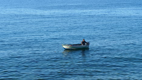Lone-fisherman-throwing-bait-at-sea.-Static