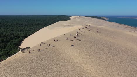 La-Gente-Camina-Sobre-La-Duna-Du-Pilat-En-La-Cuenca-De-Arcachon-Con-Una-Altura-De-Más-De-100-Metros,-Tiro-Aéreo