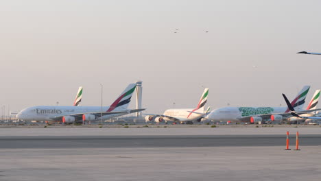Jet-Despegando-Por-Encima-De-Los-Aviones-Emirates-A380-En-Tierra-En-El-Aeropuerto-Al-Maktoum