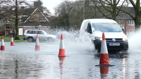 Sturm-Christoph-Vans-Fährt-Regnerisch,-Stark-überflutete-Dorfstraße,-Spritzende-Straßenkegel