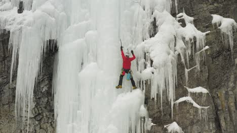 Ice-climber-on-frozen-ice-cascade-preparing-to-move-up-Maineline,-Mount-Kineo