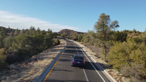 Driving-navy-blue-BMW-M3-on-empty-highway-in-Arizona,-USA,-aerial