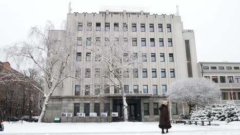 Kaunas-city-Municipal-building-while-old-white-woman-walks-by