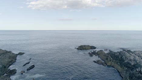 Aerial-tracking-outward-to-sea-from-the-inlet-to-Smoo-cave,-Sutherland,-Scotland