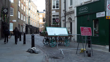 Während-Der-Zweiten-Nationalen-Coronavirus-Sperre-Gehen-Menschen-In-Einem-Sehr-Ruhigen-Covent-Garden-An-Einem-Straßenschild-Mit-Der-Aufschrift-„Straße-Wegen-Sozialer-Distanzierung-Gesperrt“-Vorbei