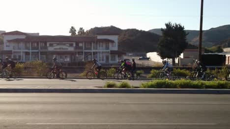 Grupo-De-Ciclistas-En-El-Camino-Por-La-Mañana-Con-El-Sol-Saliendo