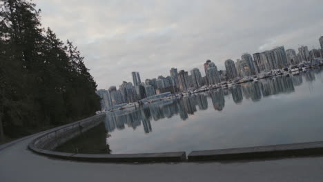 Wide-rotating-shot-of-a-Stanley-park-trail-and-boats-in-marina,-Morning-Vancouver-West-End,-Slowmotion