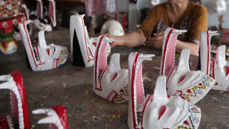Alte-Javanische-Frau-In-Der-Werkstatt,-Die-Viele-Traditionelle-Javanische-Masken-Herstellt