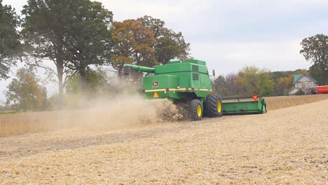 Slow-motion-shot-of-a-John-Deere-9600-Combine-harvesting-soybeans-in-Ontario,-Canada