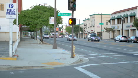 Standing-on-a-Los-Angeles-city-sidewalk-waiting-for-the-traffic-light-to-change-so-I-can-cross-the-street-next-to-a-pedestrian-sign