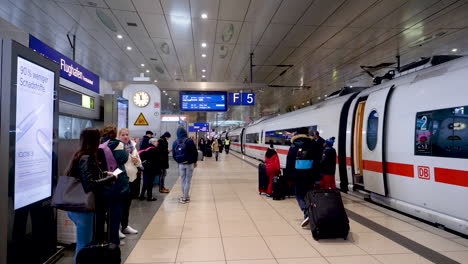 Static-shot-of-people-entering-a-german-train-that's-about-to-leave