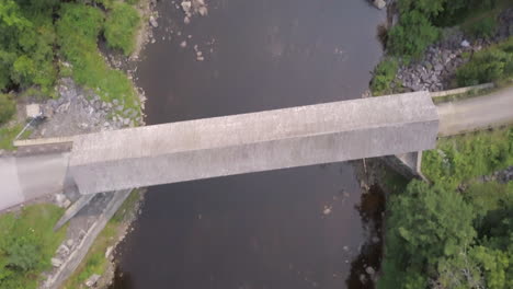 Aerial-shot-flying-above-the-Piscataquls-River-and-the-covered-wooden-Lowes-Bridge-in-Maine