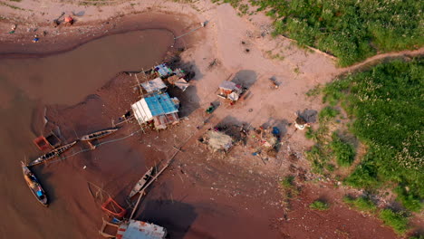 Aerial-drone-footage-flying-over-a-fisherman-floating-house-on-the-Mekong-shore