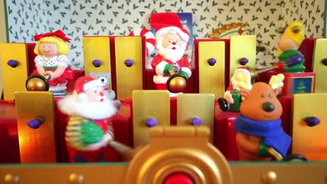 Dorking,-England---August-07-2018:-Christmas-musical-box-showing-Santa-Claus-and-his-helpers-playing-tunes-on-a-toy-xylophone