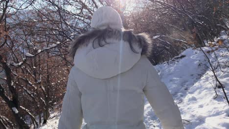 Inspirational-footage-of-woman-walking-in-a-snowy-mountain-during-the-winter-on-a-sunny-day