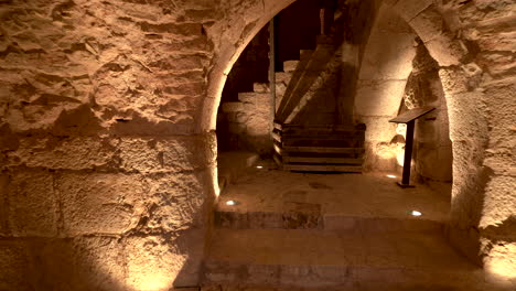 Ein-Niedriger-Durchgang-In-Die-Ruinen-Der-Burg-Kerak,-Der-Treppen-Und-Goldenes-Licht-Offenbart,-Das-Auf-Die-Steinmauern-Geworfen-Wird