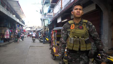 Ein-Soldat-Auf-Der-Straße-Im-Muslimischen-Viertel-Von-Mindanao,-Der-Sein-Gewehr-Trägt-Und-Mit-Munitionsmagazinen-Beladen-Ist
