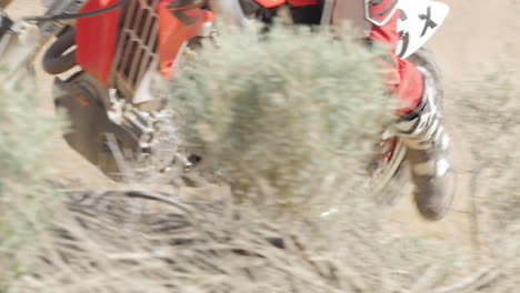 Zeitlupe:-Ein-Dirtbiker-Fährt-Mit-Seinem-Roten-Motorrad-Durch-Die-Wüste-Und-Peitscht-Um-Eine-Berme