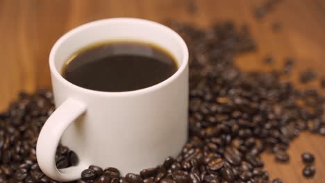 Warmer-Kaffee-Mit-Dampf-Und-Kaffeebohnen-Umgeben