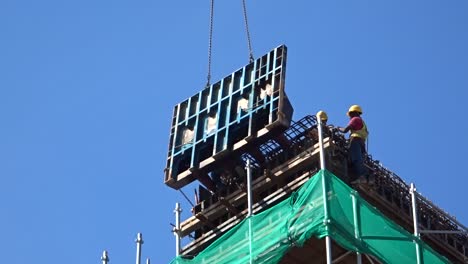 Construction-workers-working-at-height-installing-reinforcement-bar-and-form-work-at-the-construction-site