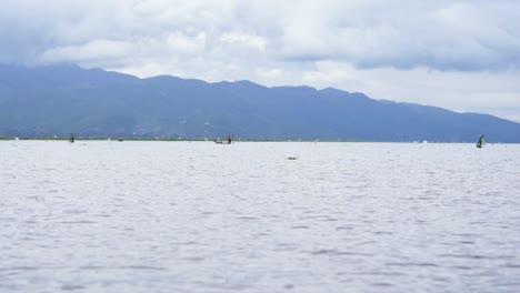 Fishermen-and-mountainside-reflection-on-Inle-Lake,-Myanmar