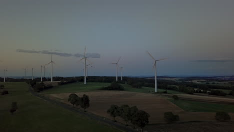 Drone-shot-over-european-field-with-pinwheels-after-sunset