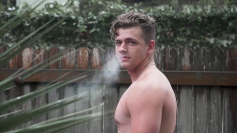 Male-Model-Looking-Back-at-Camera-Blowing-Smoke-Slow-Motion