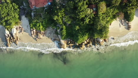 Drone-aerial-view-rocky-coast-beach-with-turquoise-colored-water-sunset,-Jurere-Internacional,-Florianopolis,-Santa-Catarina,-Brazil