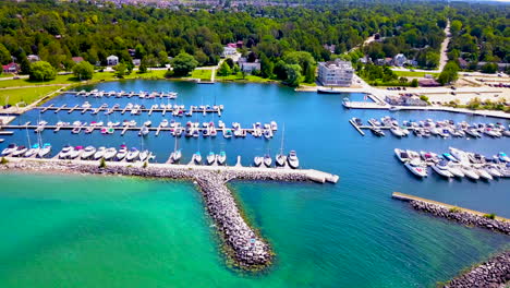 Aerial-view-of-sailboats-in-a-marina-surrounded-by-turquoise-water-on-a-sunny-day