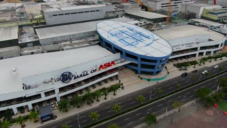 A-slow-reverse-dolly-shot-revealing-a-sparse-looking-Mall-of-Asia-as-some-cars-go-by