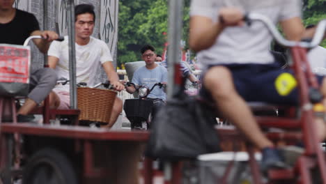 Heavy-traffic-of-motorbikes---rickshaws-loaded-with-textile-rolls-in-the-textile-market-area-in-Guangzhou,-China