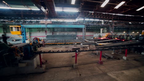 Men-are-working-in-steel-rods-factory,-Hot-steel-roads-in-process,-camera-panning-view