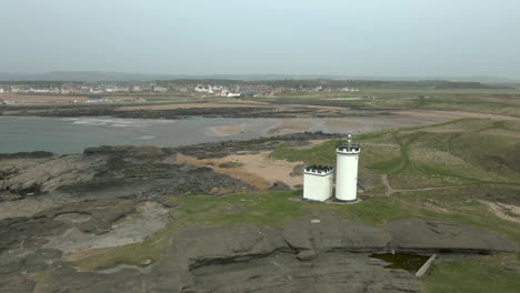 An-aerial-view-of-Elie-Ness-lighthouse-and-surrounding-coastline-on-a-misty-day,-Fife,-Scotland