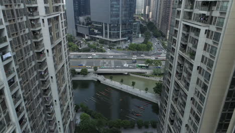 Luftaufnahme-Eines-Wohnblocks-In-Der-Innenstadt-Von-Guangzhou,-Mit-Bürogebäuden-Im-Hintergrund-Und-Einer-Autobahn-Mit-Dichtem-Verkehr,-An-Einem-Sonnigen-Nachmittagstag,-Guangdong,-China